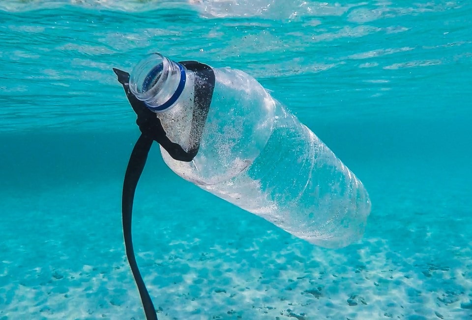 A plastic bottle floats in blue ocean water